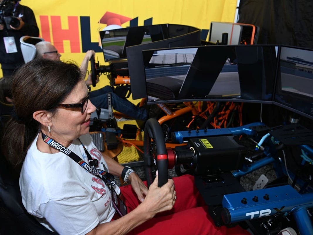Caption: Governor Kelly Ayotte steps into the racing simulator to take on NASCAR legend Mark Martin.
