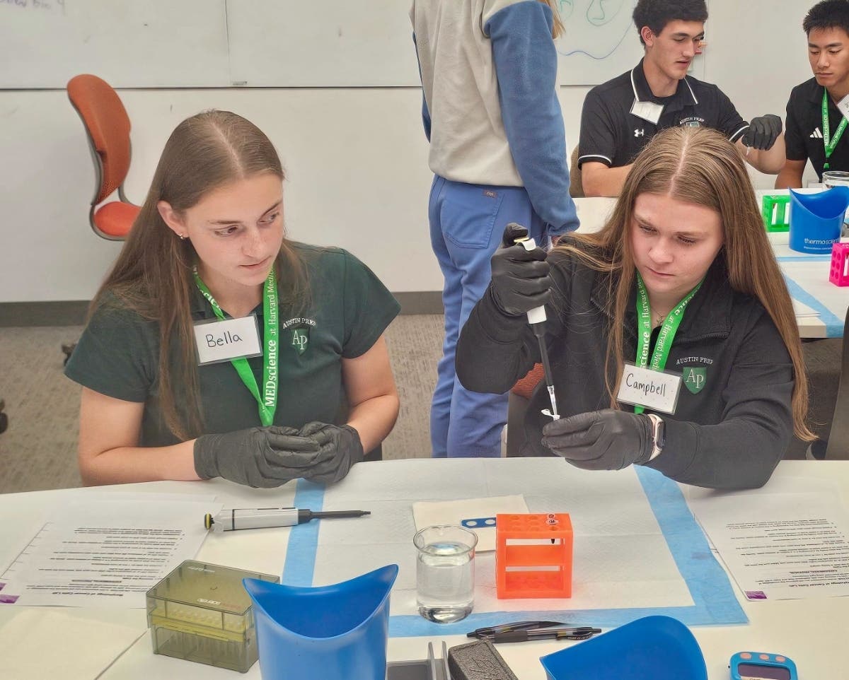 Austin Prep senior Campbell Wallin ’27, right, uses a micropipette alongside classmate Bella Ryan ’27 during a Morphology of Cancer Cells Lab at Harvard Medical School as part of Austin Prep’s MEDscience experience.