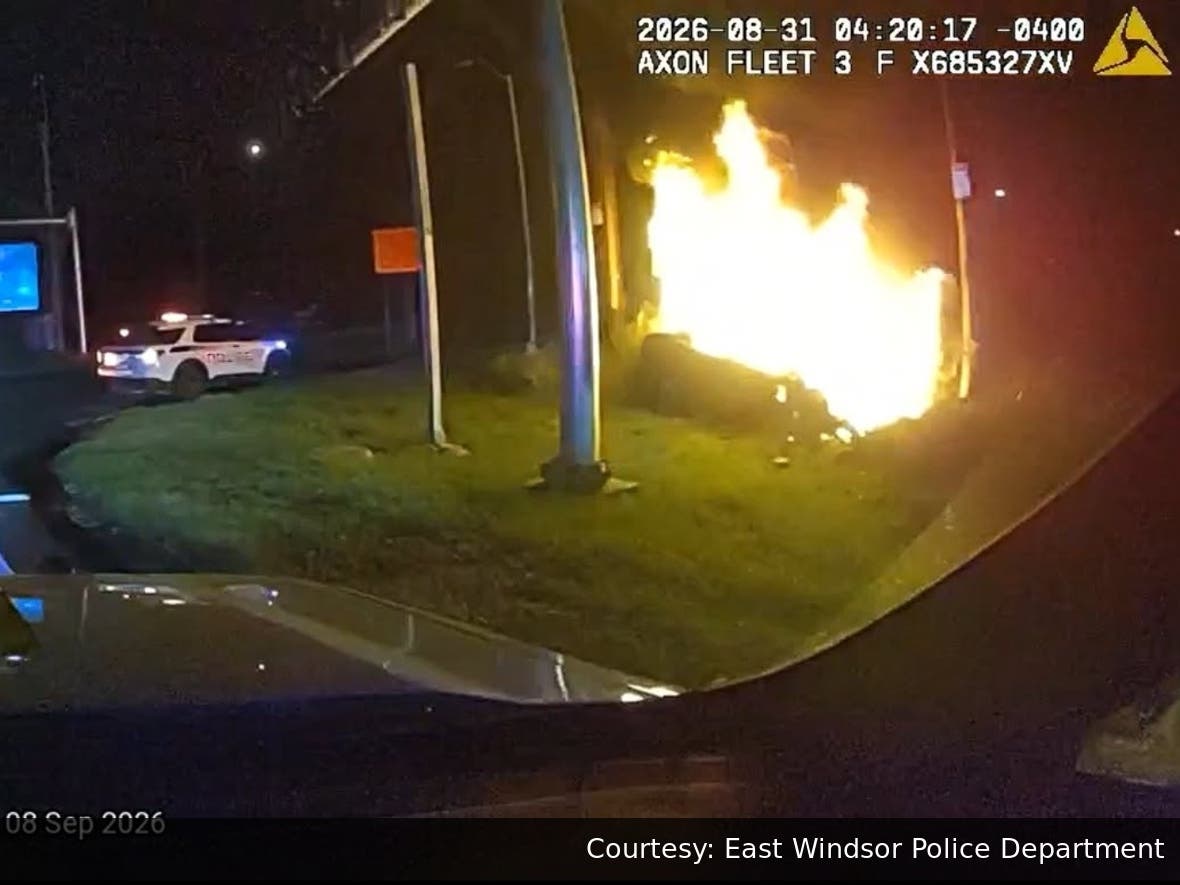A vehicle was engulfed in flames minutes after two East Windsor police officers pulled an unconscious driver from the wreckage, police said.