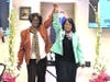 Elder Jane Wells and Regina Gahunia meet at the Bridge of Peace, symbolizing interracial harmony.