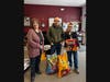 PAWS President Robin Gorfine stands with Jordan Yu and his father Milton, accepting the pet food donations they brought in on Saturday.
