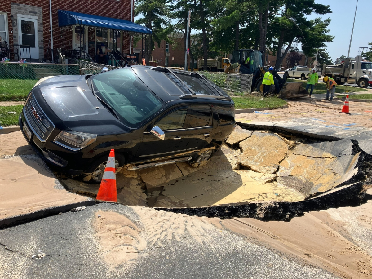 An SUV became trapped inside a sinkhole in Dundalk that was caused by a water main break.