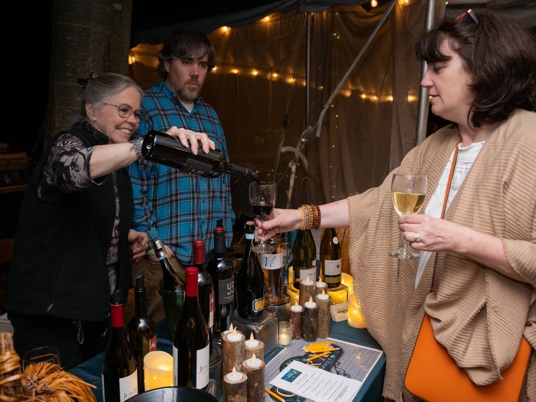 Betsy Thompson of Cellar XV pours for Kristine Keaveny at Woodcock Nature Center.