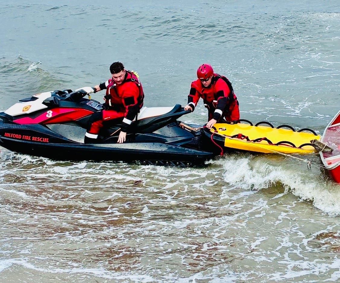 Milford firefighters rescued two people after their canoe capsized about 300 yards offshore Monday evening.