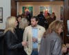 Guests enjoy the #WeAreGreekWarriors opening reception at Hellenic Museum of Michigan. Portraits of Domna Vizvizi (L) and Moscho Tzavela (R) are visible in the background.