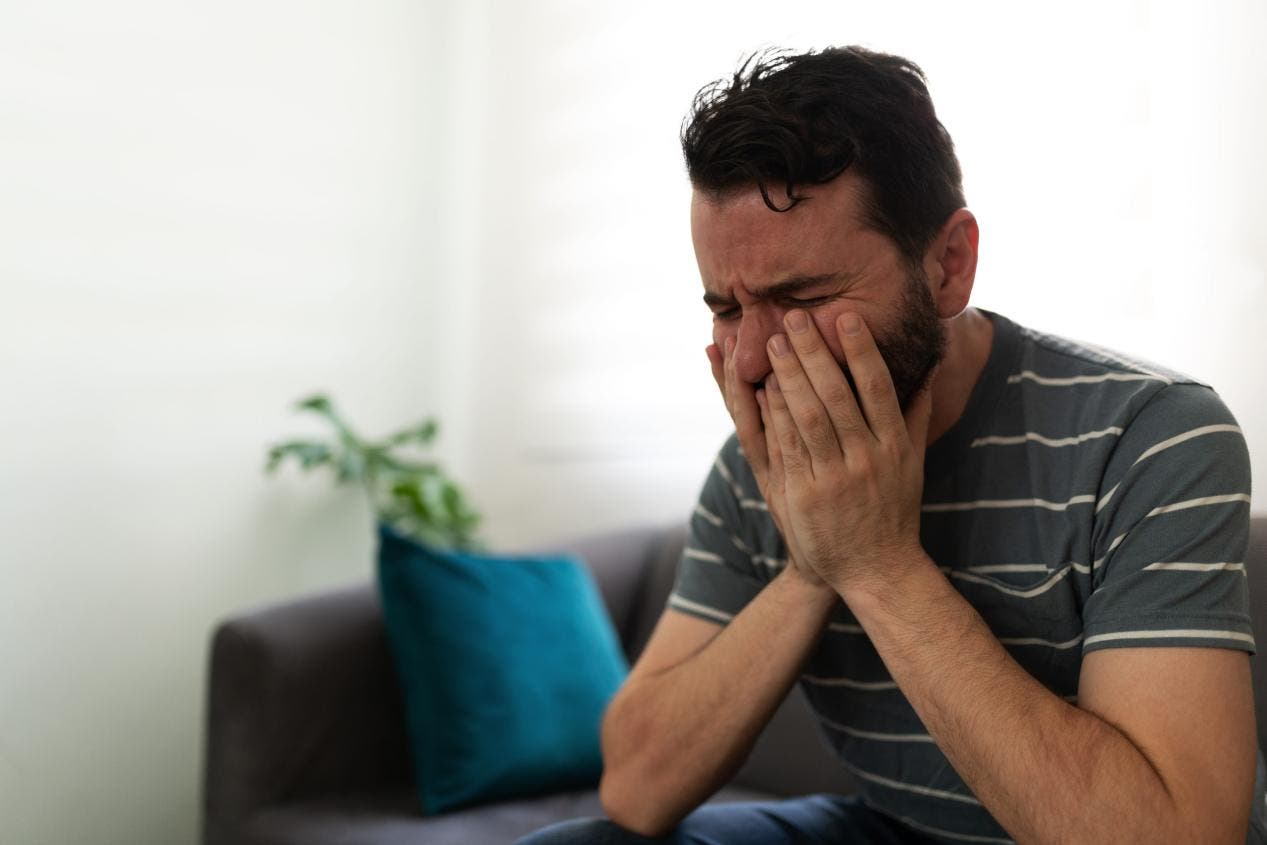 Adult sitting quietly at home after work feeling emotionally overstimulated and mentally drained