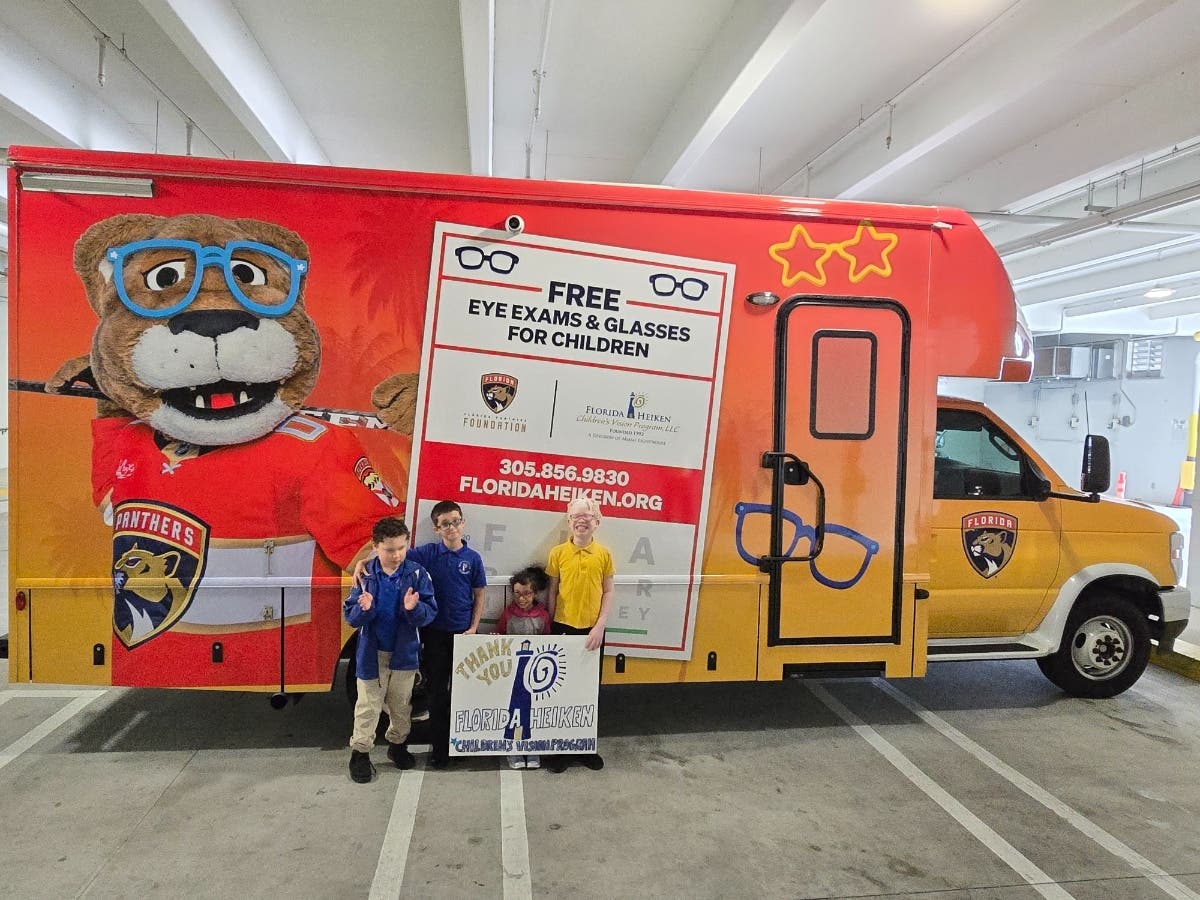 Early elementary schoolchildren outside the Florida Heiken Children’s Vision Program mobile eye care van receiving free comprehensive eye exams.