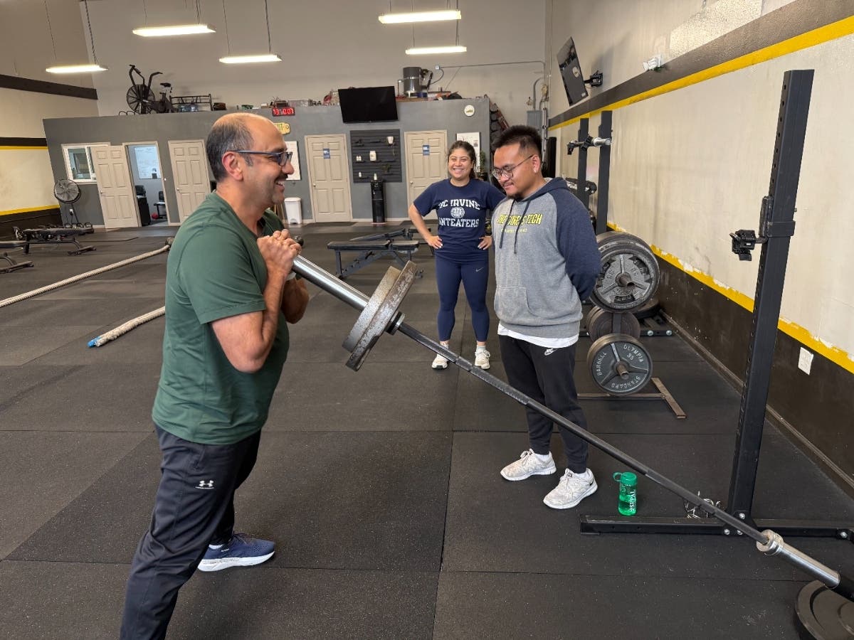 A trainer works with a client at The Fitness Tech in South San Francisco while another member looks on — the kind of personalized attention that has helped hundreds of local adults over 40 get fit, feel stronger, and actually enjoy the process.