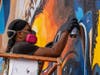 Artist Brian Peterson paints the mural at Scholarship Prep South Bay as part of his five murals in six days project. 