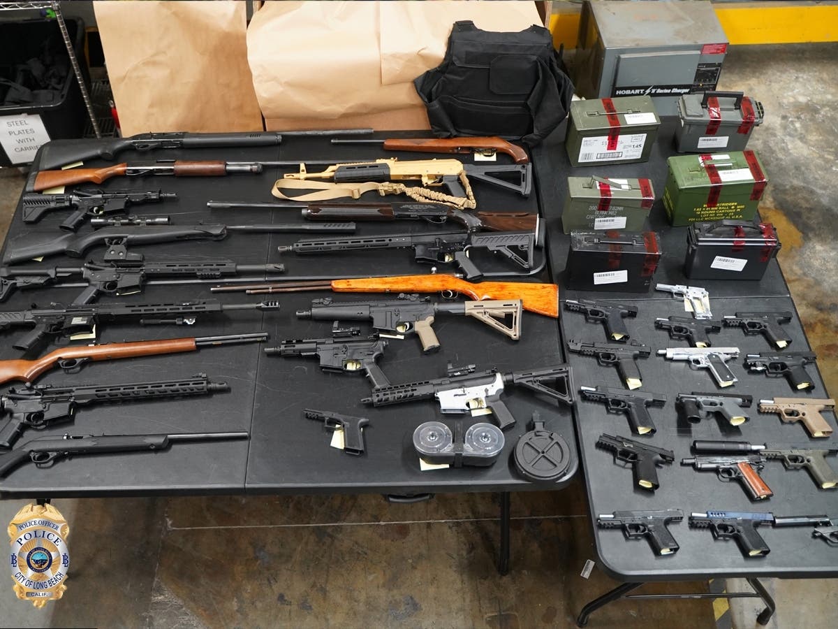 Long Beach police recovered 32 firearms, more than 2,000 rounds of ammunition and body armor while serving a search warrant at a Long Beach home, authorities said.