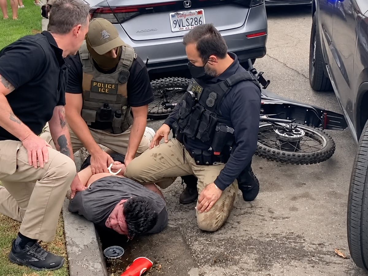 Federal immigration agents restrain Ricardo Gonzalez, a 40-year-old U.S. citizen, in North Long Beach on Oct. 17, 2026. New surveillance footage appears to show an ICE SUV swerving toward him moments before the confrontation.