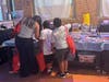 Parents and children browse books together.