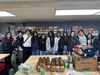 Edison High School student volunteers gather inside the food pantry after wrapping up a day of stocking shelves and serving the community.
