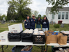 (From left) former Vice President Kayen Lo, former President Chris Saavedra, and incoming co-presidents Rishitha Jambula and Ann-Marie Gonzalez stand together to pose for a photo behind organized materials.