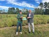 Fairgrown Farm owner James Klett receives books alongside New Jersey Agriculture Secretary Ed Wengryn.