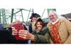 Guests pose for a photo with historical reenactors during a Revolutionary Crawls & Events gathering.