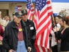 Veterans proceed through a wall of American flags into WLHS Veterans Day observance event.