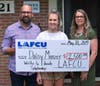 LCC-bound Daisy Manzer, center, receives the scholarship from LAFCU's Alyssa Sliger. Manzer's dad is also pictured.