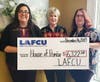 LAFCU's Amanda Seger, left, and Teri, right, present a check to Shari Montgomery of House of Promise in the amount of $6,322.50 from funds raised by LAFCU and its employees.