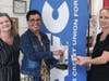 Bethany Augustine, at right, receives the ATHENA Leadership Award pendant at a surprise presentation. Also pictured is, from left, Amy Hoyes, Grand Ledge Chamber of Commerce, and Kelli Ellsworth Etchison, LAFCU.