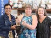 Pam Redman, center, receives the ATHENA Leadership Award pendant at a surprise presentation. Also pictured is Kelli Ellsworth Etchison, LAFCU, at left, and Amy Hoyes, Grand Ledge Chamber of Commerce, right.