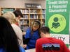 At the final booth of the Financial Reality Fair, Christine Wood, LAFCU executive administrative assistant, counsels a student on how he might improve his financial decision-making after reviewing his budget for living independently as an adult. 