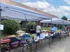 Volunteers from LAFCU, The Village Lansing, and the Capital Area District Library organize supplies before nearly 400 attendees arrive for the second annual Back-to-School Extravaganza giveaway event held at The Village Lansing.