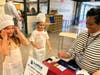 First grade students at Winans Elementary step up to the register to "pay" for their donuts, gaining hands-on financial experience, before decorating their sweet treat. 