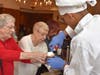 Lyons Township High School junior David Chew, of LaGrange Park, (right) puts the finishing touch on a mug of hot chocolate at a recent senior citizen holiday event.