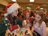 Lyons Township High School senior Jennie Bosas, of LaGrange, paints a snowflake on the cheek of one of many Holiday Write Night participants.