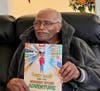 Zackery Bouey holds daughter, Swannee Rivers first children's book.