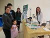 HIPPY mom Maria Castro, with HIPPY child Ashley Aca (foreground, left) and her other children Aylin Aca and Julian Aca, learn about a workshop available through the National Financial Literacy Campaign