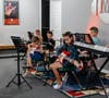 Students in grades 1-5 receive instruction on guitars and keyboards