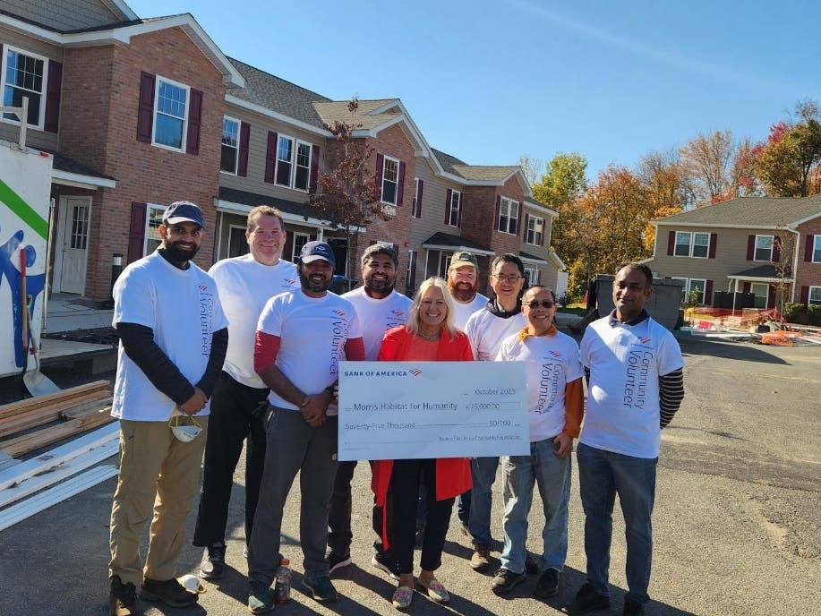 Morris Habitat for Humanity CEO, Liz DeCoursey, (center) receives a $75,000 grant from Bank of America. 