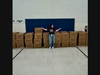 Julie Carey poses with the boxes of water bottles for the Hometown students and staff.