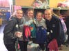 Meghan McCarthy, Madeline Lutz, Maddy Rosen and Nicolina Farmer pose with donated children's clothing at the Boston Cradles to Crayons warehouse on Saturday, Nov. 9. 