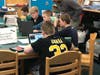 Ravi Sangha, sixth grade math teacher, helps students at the rock paper scissors coding station at the Hour of Code event on Wednesday, Dec. 11.