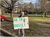 Fourth grade student Jackson Shaughnessy stands with a poster made by students to promote Basil during school drop off and pick up. 