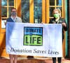 April is DONATE LIFE Month - Medfield Town Admin, Kristine Trierweiler holds the Donate Flag with Liz Sandeman, New England Donor Services volunteer and Medfield Lion.