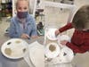 Elizabeth (left) and Andrew, fifth graders at the Dale Street School, complete a hands-on activity as part of a chemical reactions and mixtures kit provided by nonprofit Science & Engineering Education Development and funded by the Mass Cultural Council.