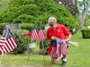 Frank Iafolla planting a flag at the grave of Peter Kristof in Vine Lake Cemetery.