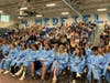 MHS Juniors in the stands and MHS Class of 2022 Seniors in graduation robes.