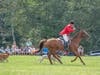 Huntsman Steve Farrin leading Norfolk Hounds while blowing horn  