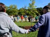 MHS Class of '72 hold hands and circle the new Linden tree planted to commemorate their 50th Class Reunion.