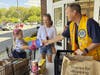 Lion Chris Carlin is given a large box of snacks from a young shopper.