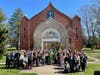The parish gathered with the diocesan bishop, Archbishop Michael, in front of the temple building at Palm Sunday.