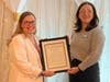President Mary Pilon receives congratulations from representative for Congresswoman Debbie Dingell.
