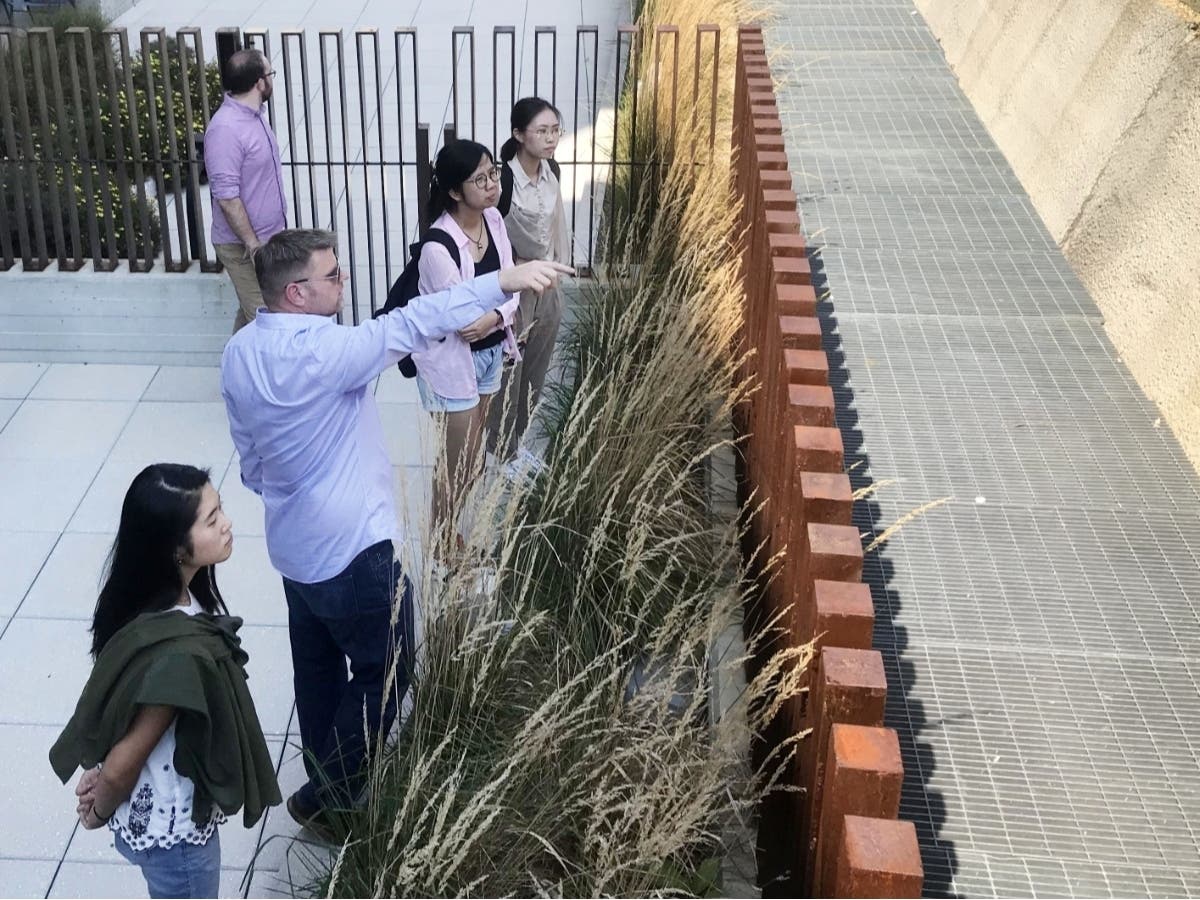 Bryan Bays, PLA, TSW principal and director of the firm’s Landscape Architecture Studio (center, pointing), discusses elements of a project site with landscape architecture students.