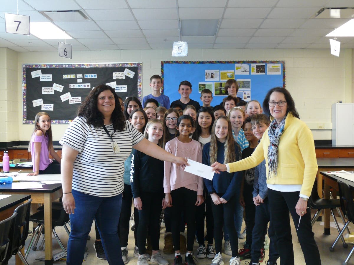 Teacher Stacy Smiler (left) is happy to receive a donation from the Rochester Garden Club