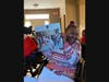 Phillipa, who receives support from Trinity’s Residential Network III, smiles with a BTS calendar she received on Christmas morning at her home in Joliet.